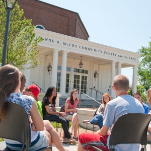 Students seated outside having a discussion.