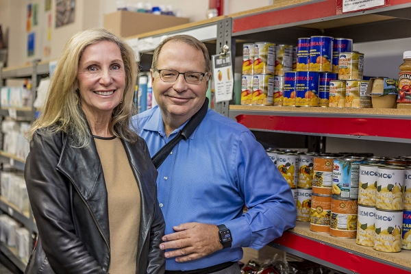 2021 McCoy Award community service award winners Patti and Steve Steinour standing together near food pantry shelves.